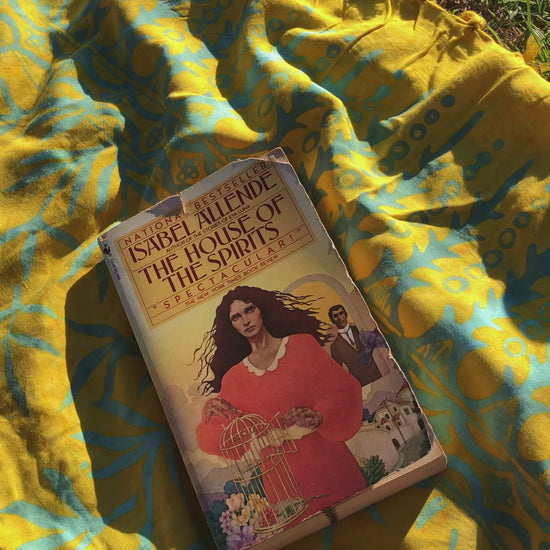 The Lanta Reef - Yellow sarong is used as a picnic blanket at the park. A book sits on top of the sarong