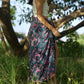 A woman wears the Butterfly - Dark Slate sarong from YUMI & KORA as a skirt. Our sarongs can be tied into a sarong skirt or a sarong dress. Our sarongs work great as a swimsuit coverup