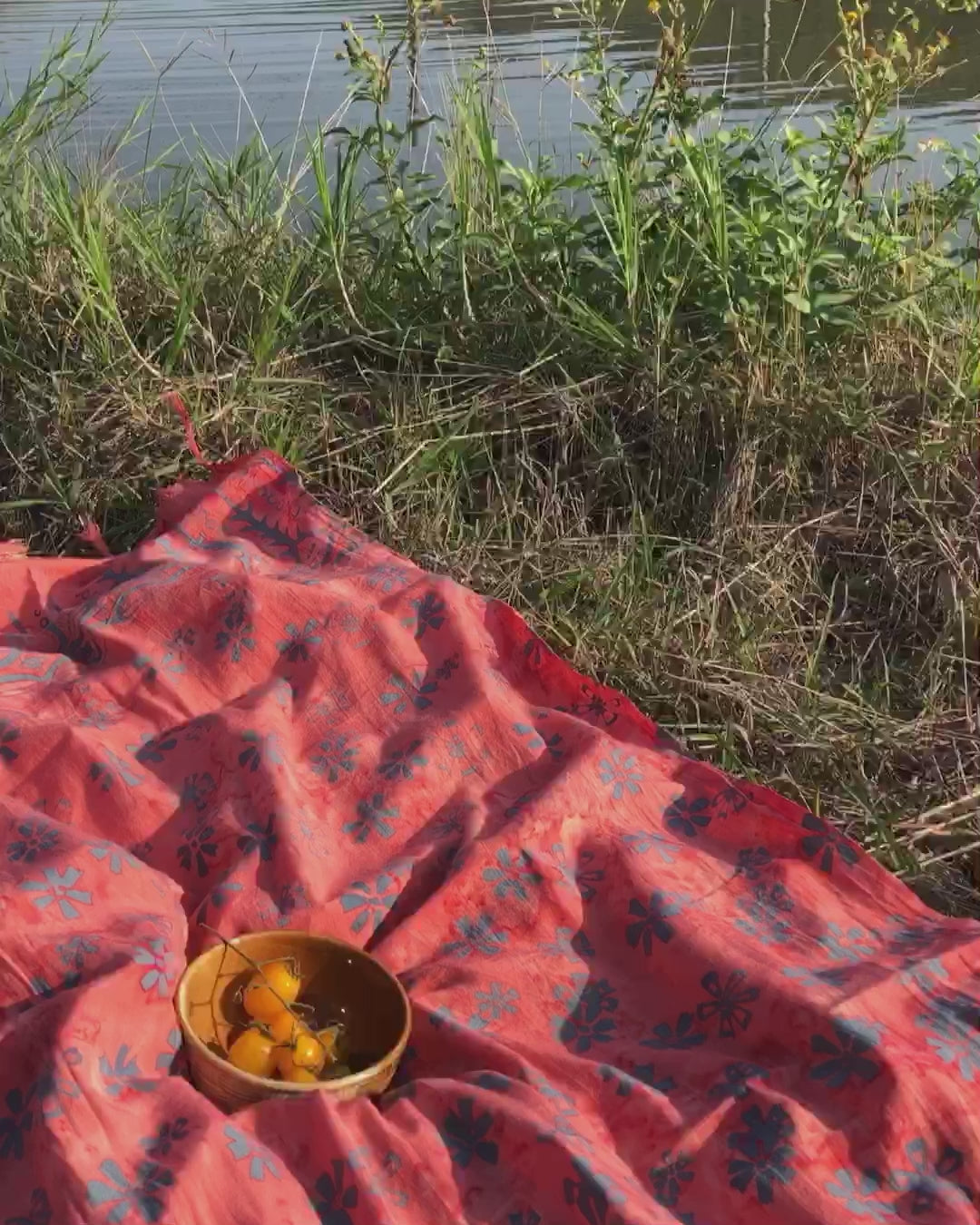 The Sweet Cosmos - Pink sarong from YUMI & KORA is used as a picnic blanket. Some cherry tomatoes sit on top of the sarong