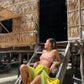 A woman wears the Lanta Reef - Yellow sarong from YUMI & KORA as a swimsuit cover-up skirt at the beach